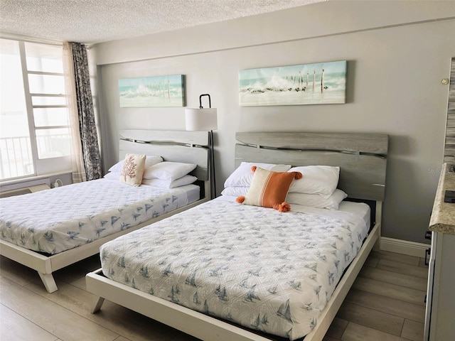 bedroom featuring wood-type flooring and a textured ceiling