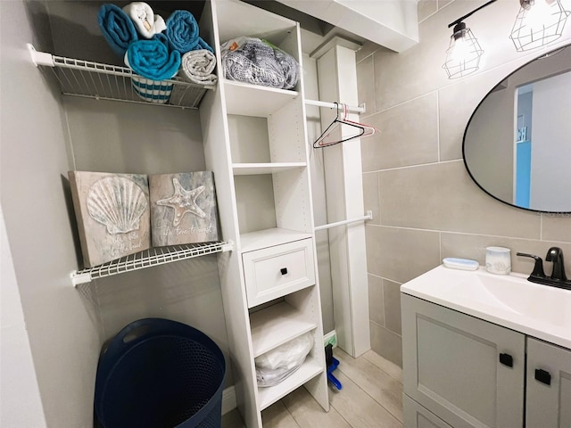 bathroom with vanity, tile walls, and wood-type flooring