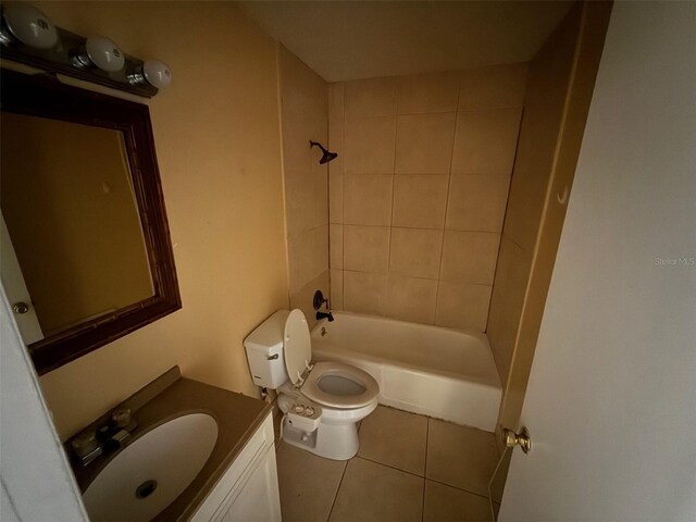 full bathroom featuring tile patterned flooring, vanity, tiled shower / bath combo, and toilet