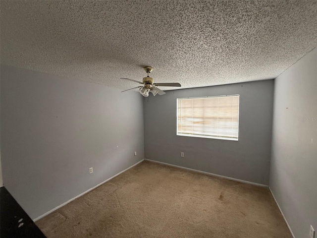 carpeted spare room with ceiling fan and a textured ceiling