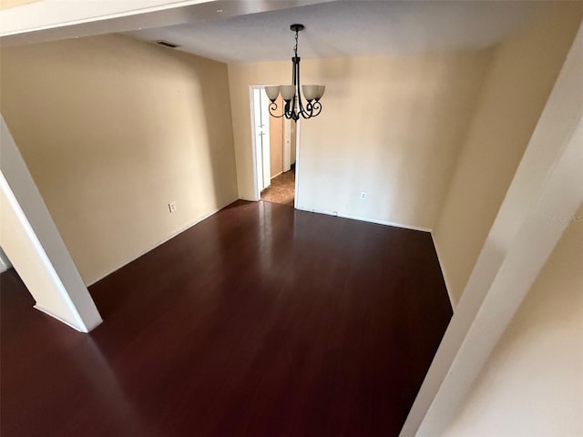 unfurnished dining area with wood-type flooring and an inviting chandelier