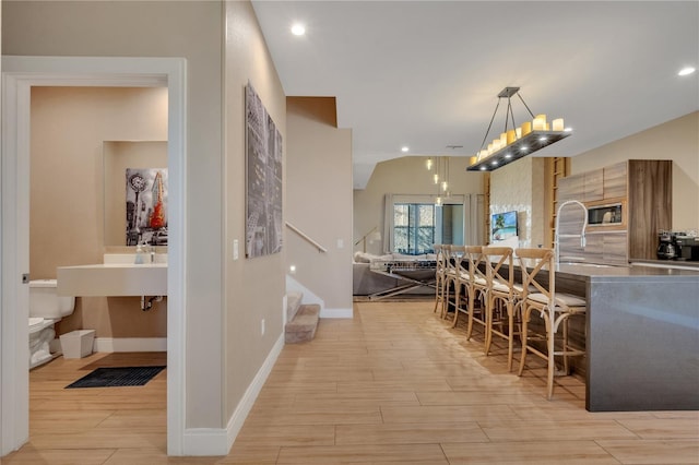 dining space featuring light hardwood / wood-style floors and vaulted ceiling