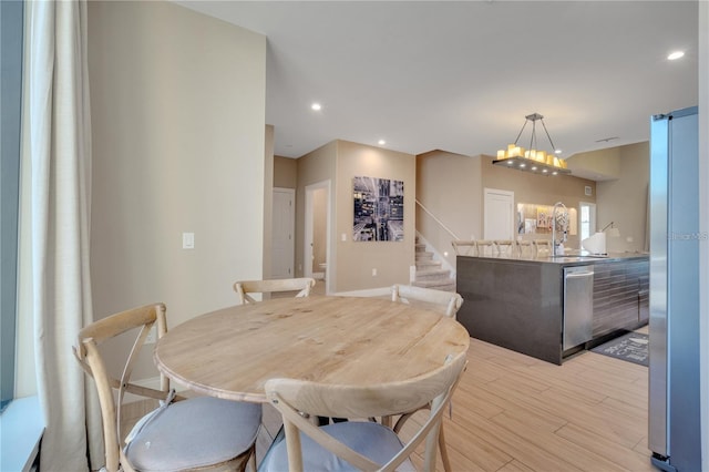 dining room with light hardwood / wood-style floors, a barn door, and sink