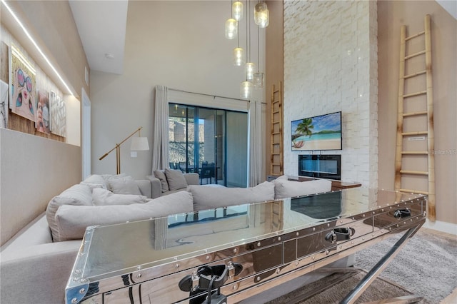 living room featuring a high ceiling and a fireplace