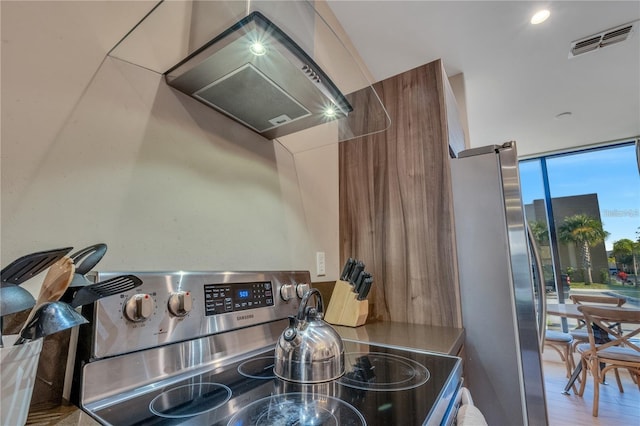 kitchen with hardwood / wood-style flooring, stainless steel appliances, and ventilation hood