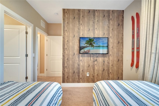 carpeted bedroom with wooden walls