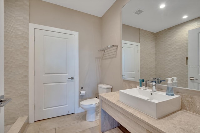 bathroom featuring walk in shower, vanity, toilet, and tile patterned floors