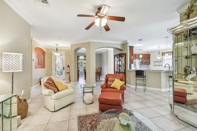 living room featuring crown molding, ceiling fan, sink, and light tile patterned floors