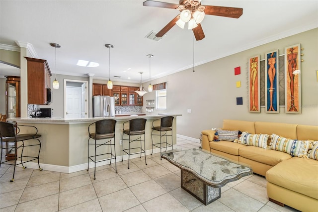 tiled living room with crown molding and ceiling fan