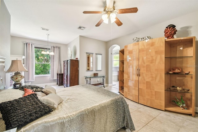 bedroom featuring light tile patterned floors and ceiling fan with notable chandelier