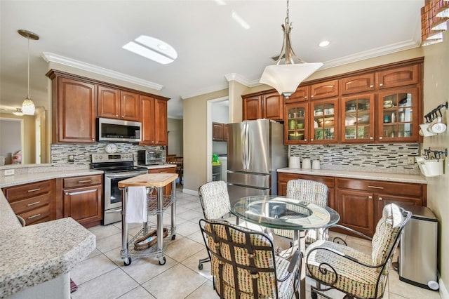 kitchen with crown molding, appliances with stainless steel finishes, decorative backsplash, and hanging light fixtures