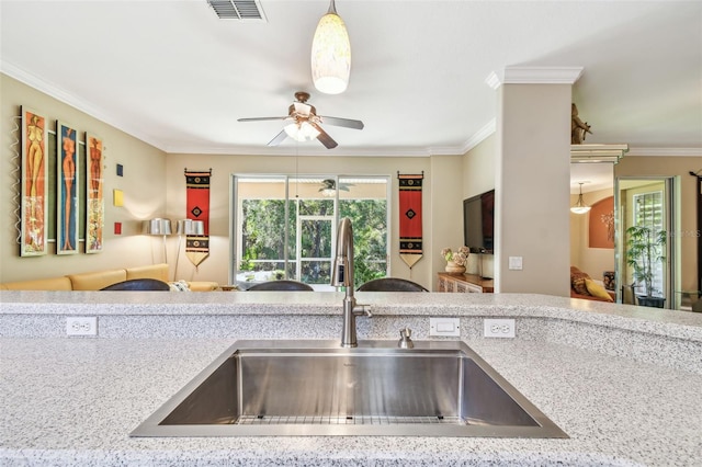 kitchen with ornamental molding, sink, pendant lighting, and ceiling fan