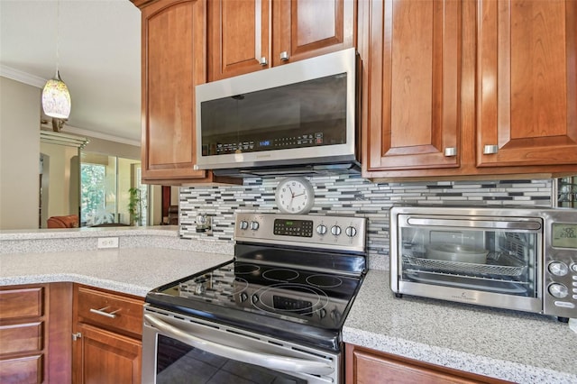 kitchen featuring ornamental molding, decorative light fixtures, stainless steel appliances, and backsplash