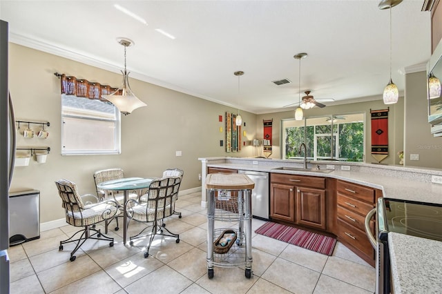 kitchen featuring appliances with stainless steel finishes, sink, hanging light fixtures, and light tile patterned floors