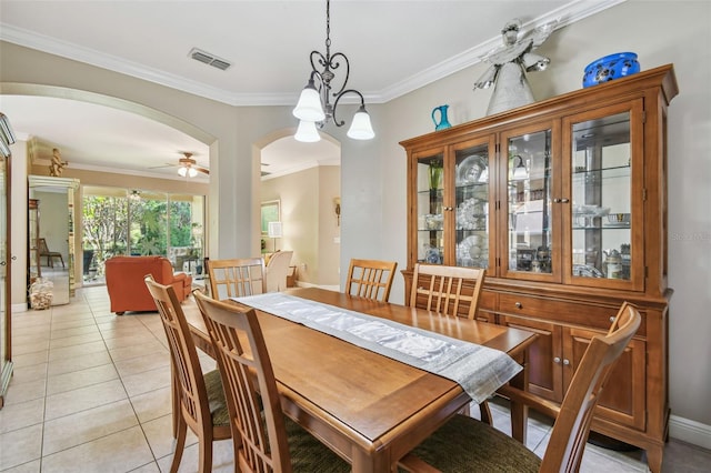 tiled dining space featuring ornamental molding and ceiling fan with notable chandelier