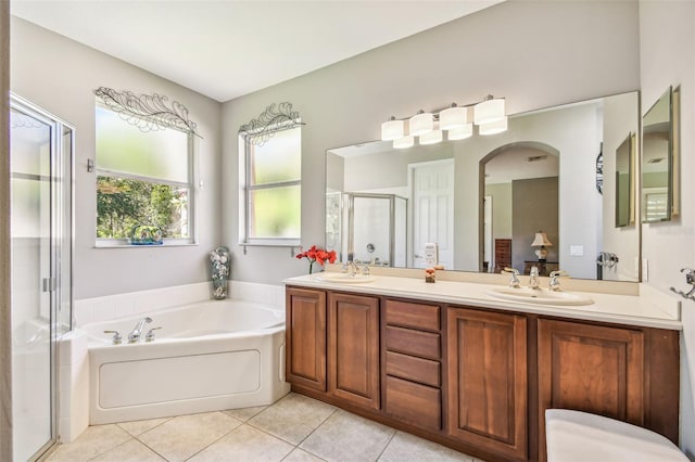 bathroom with vanity, tile patterned flooring, and plus walk in shower