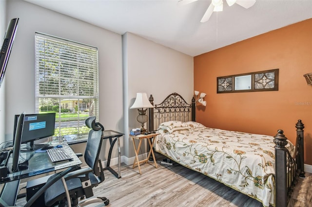 bedroom featuring multiple windows, hardwood / wood-style flooring, and ceiling fan