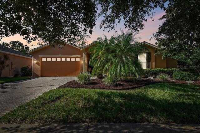 view of front of home with a lawn and a garage