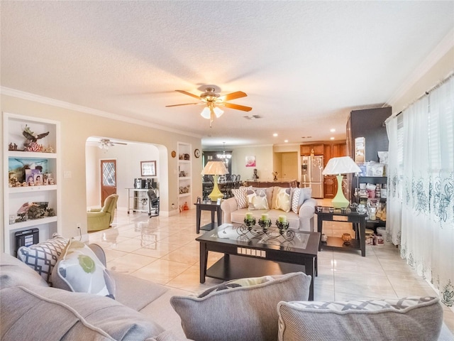 tiled living room with ornamental molding, ceiling fan, a textured ceiling, and built in shelves