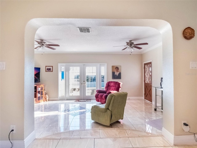 living room with french doors, crown molding, a textured ceiling, and ceiling fan