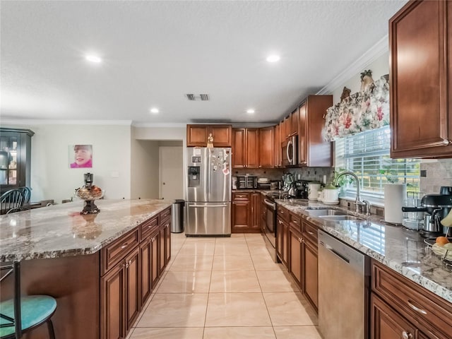 kitchen featuring backsplash, a kitchen breakfast bar, sink, crown molding, and stainless steel appliances