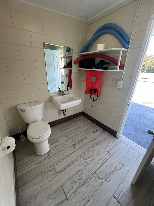 bathroom featuring toilet, sink, and wood-type flooring