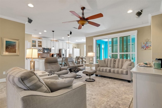 living room featuring ornamental molding and ceiling fan