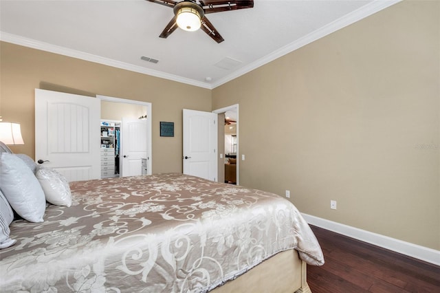 bedroom featuring a closet, a spacious closet, hardwood / wood-style floors, crown molding, and ceiling fan