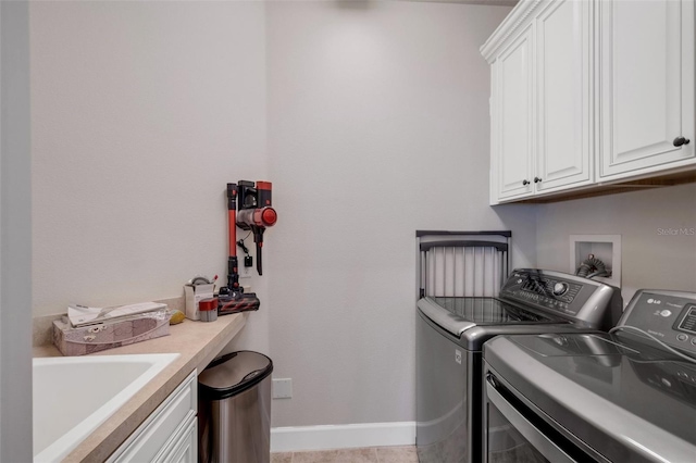 laundry area with cabinets, light tile patterned flooring, sink, and washing machine and clothes dryer