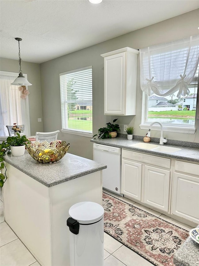 kitchen featuring white cabinets, sink, white dishwasher, and light tile patterned floors