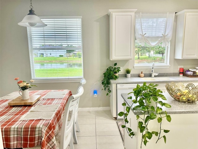 kitchen featuring sink, white cabinetry, pendant lighting, and light tile patterned floors