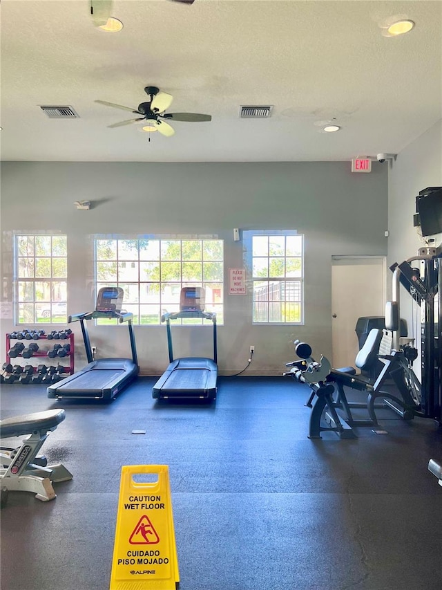 exercise room featuring a textured ceiling and ceiling fan