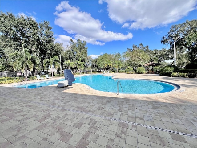 3040 Palermo Rose Way, Kissimmee, FL 34746 - community pool featuring a patio area and view of wooded area