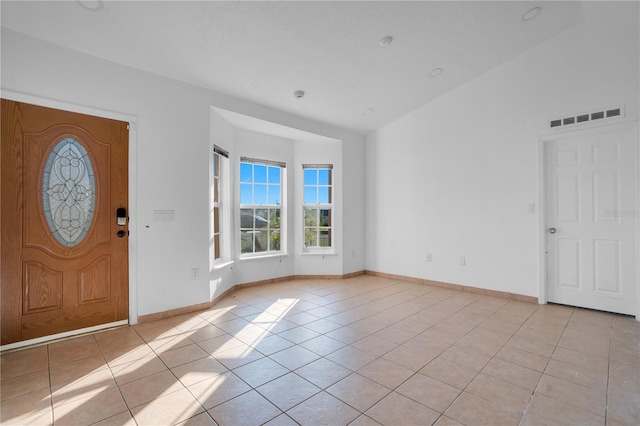 tiled entrance foyer featuring vaulted ceiling