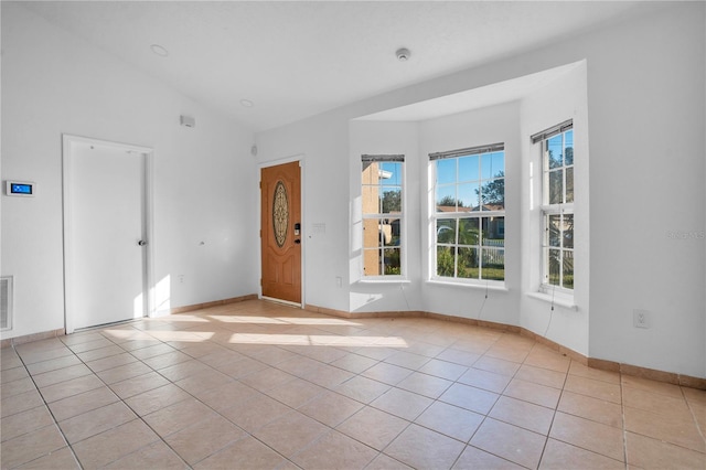 tiled spare room with lofted ceiling and a wealth of natural light