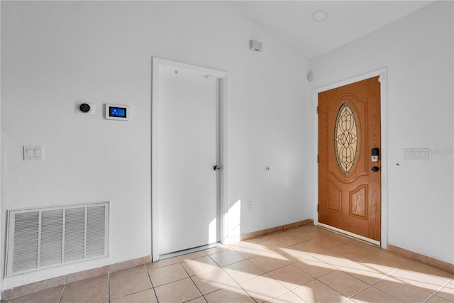 foyer with lofted ceiling and light tile patterned flooring