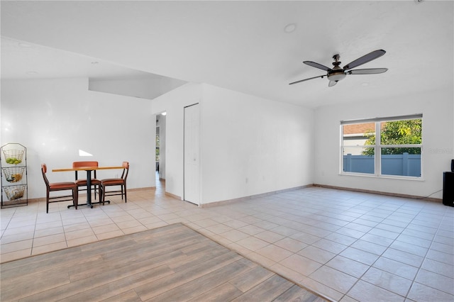 unfurnished room with lofted ceiling, ceiling fan, and light tile patterned floors