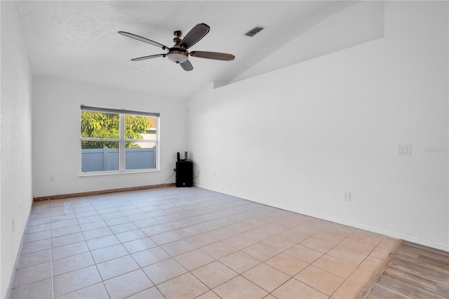 tiled empty room featuring ceiling fan, a textured ceiling, and lofted ceiling