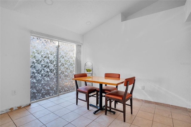 tiled dining room with lofted ceiling