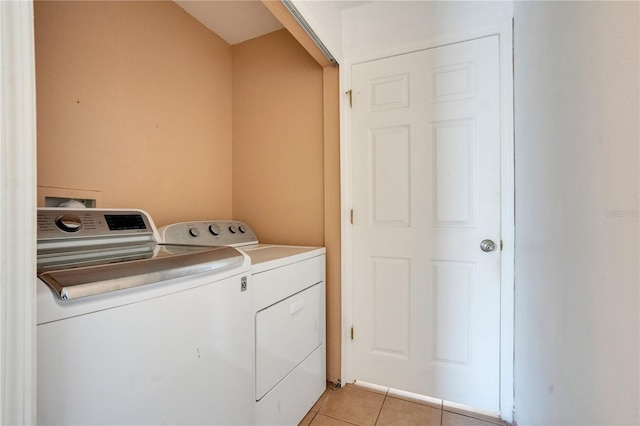 clothes washing area featuring light tile patterned flooring and separate washer and dryer