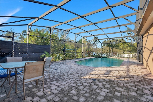 view of swimming pool featuring a patio area and glass enclosure