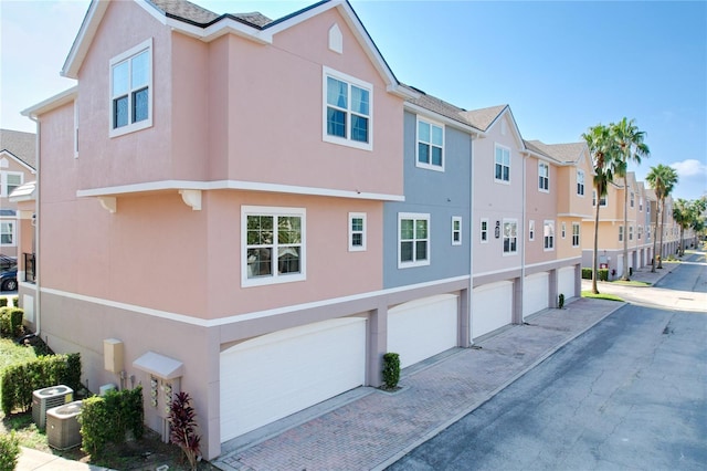 view of side of home featuring central air condition unit and a garage