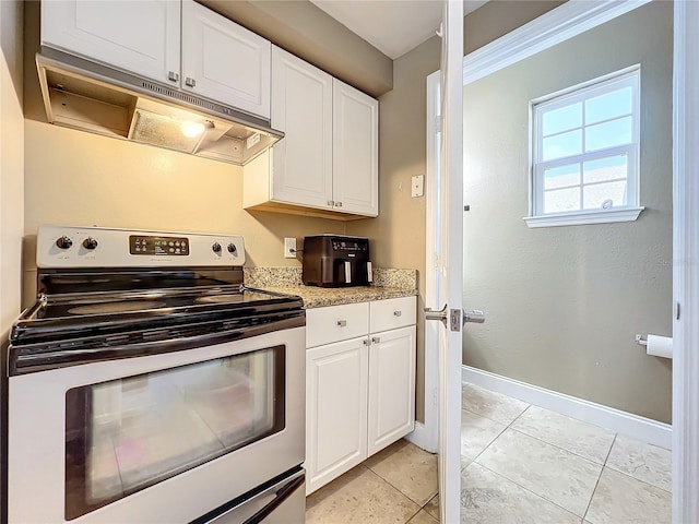 kitchen with white cabinets, electric range, and light tile patterned flooring