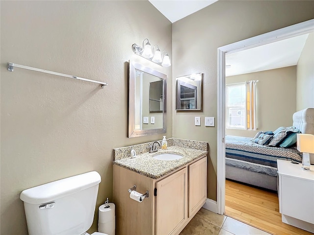 bathroom with hardwood / wood-style floors, vanity, and toilet