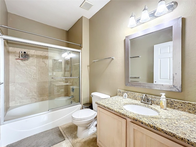 full bathroom with shower / bath combination with glass door, tile patterned floors, vanity, and toilet