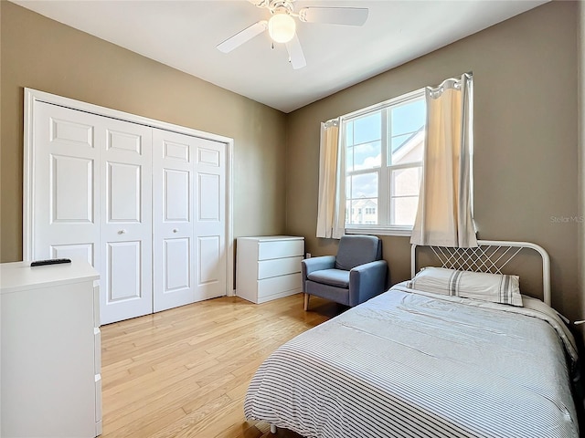 bedroom featuring ceiling fan, light hardwood / wood-style floors, and a closet