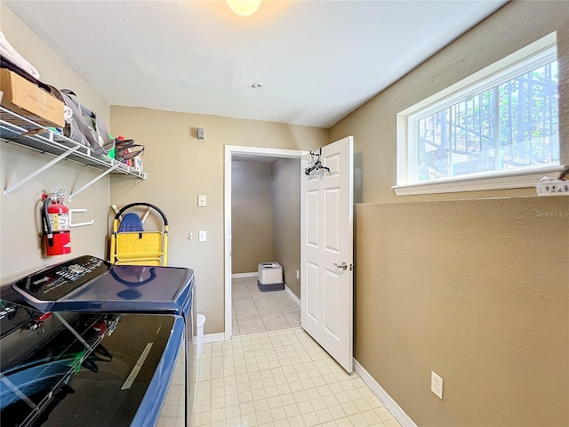 clothes washing area with washing machine and clothes dryer and light tile patterned floors