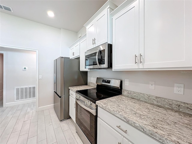 kitchen with white cabinetry, light hardwood / wood-style floors, and appliances with stainless steel finishes