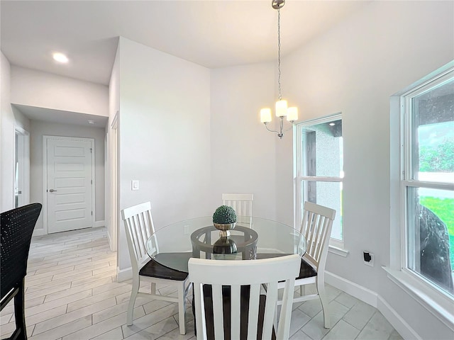 dining space with light hardwood / wood-style floors and a notable chandelier