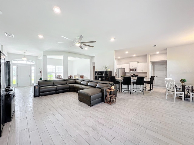 living room with light hardwood / wood-style flooring and ceiling fan